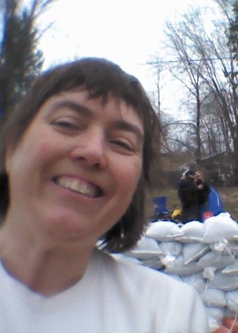 photo of Louise in front of a wall of sandbags