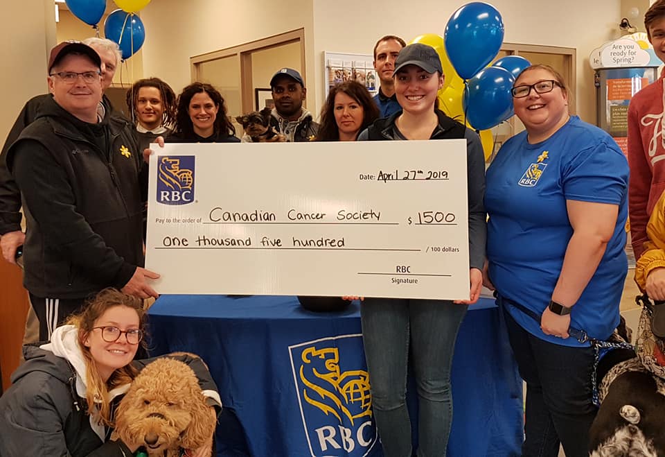 group photo of RBC staff and community members with large cheque  showing the approximate total raised ($1500).